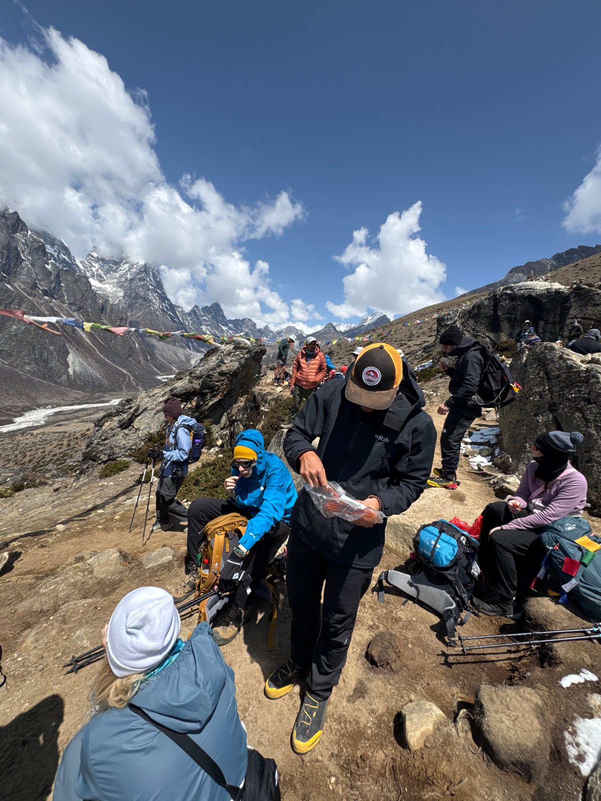 Hikers rest on steep mountain trail near Khumjung, Nepal