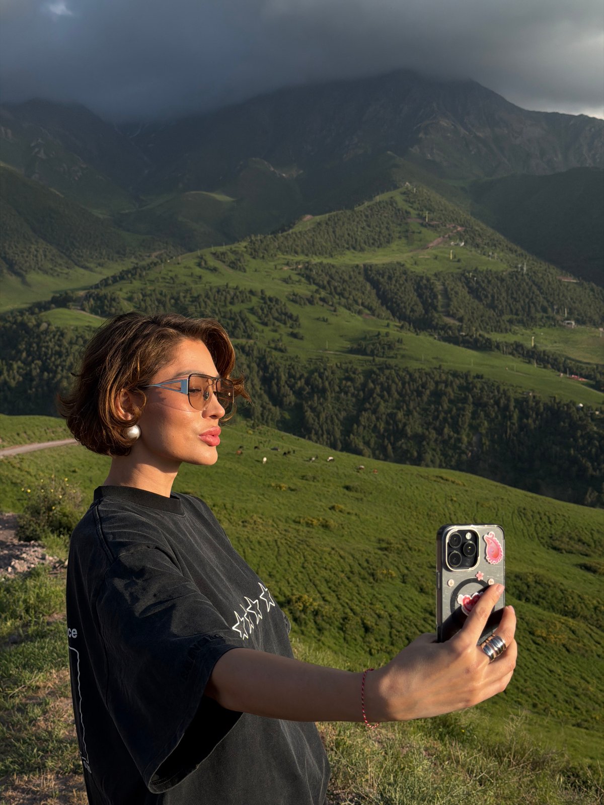 Tourists document verdant mountain scenery in Kashka Suu, Kyrgyzstan