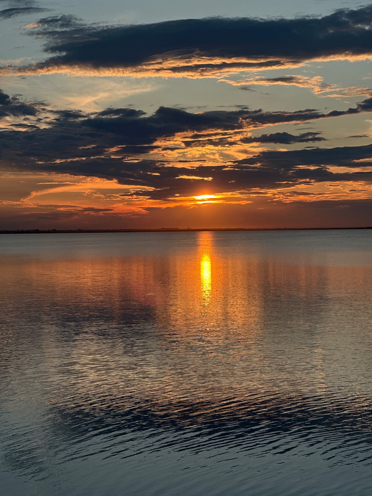 Sunset sailboat scene captured over Kokshetau lake waters