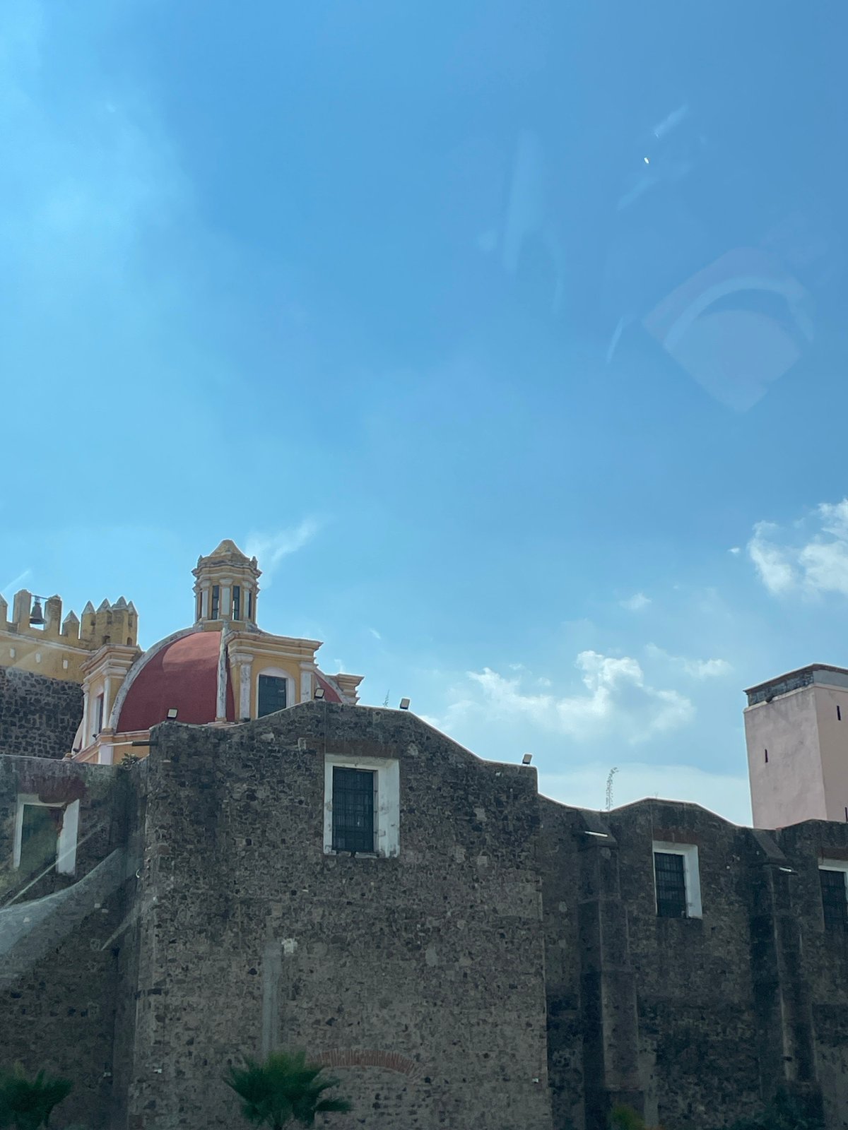 Tourist photographs historic Cholula church and pyramid complex