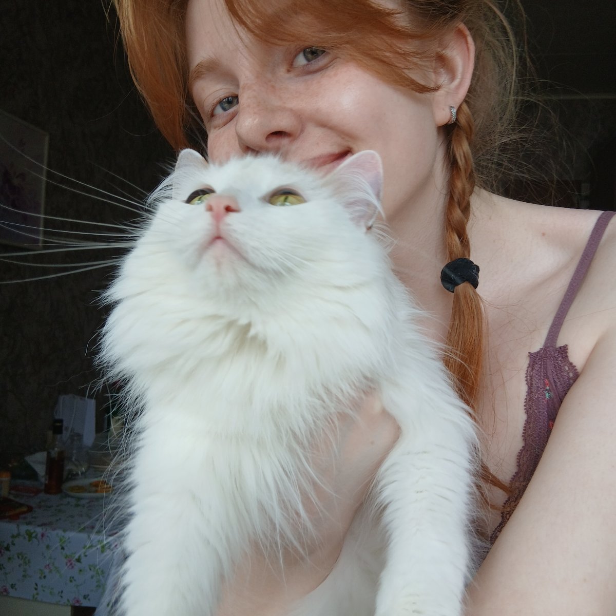 Person with red braids photographed with white cat in Yekaterinburg