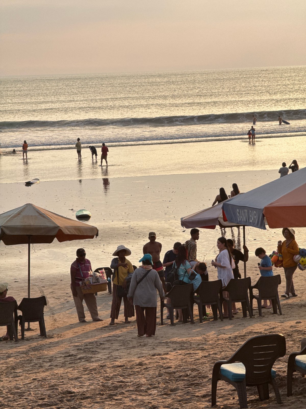Kuta Beach at golden hour: surf, vendors, and sunset crowds
