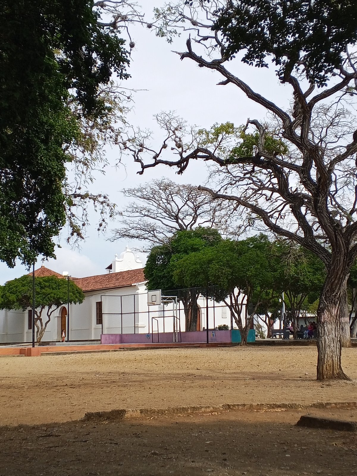 Urban plaza observed near white church building with red roof