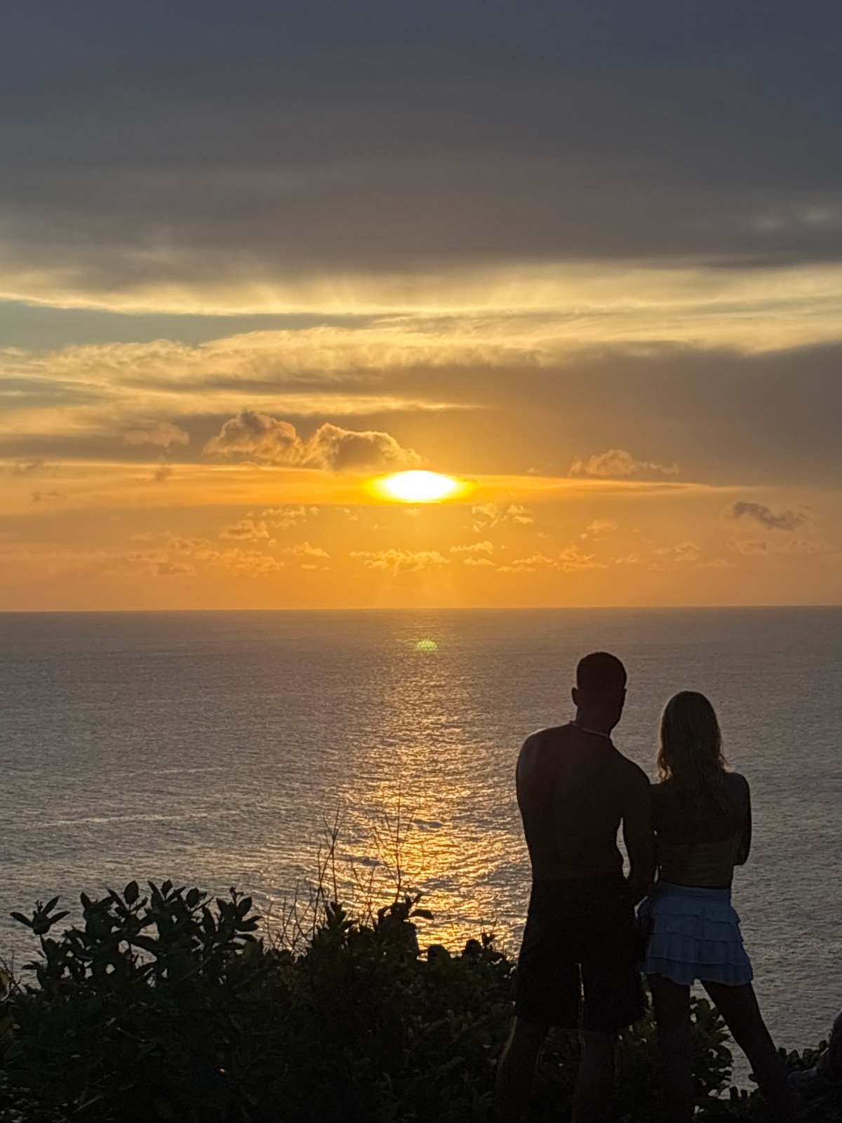 Sunset viewed through clouds over Uluwatu ocean waters