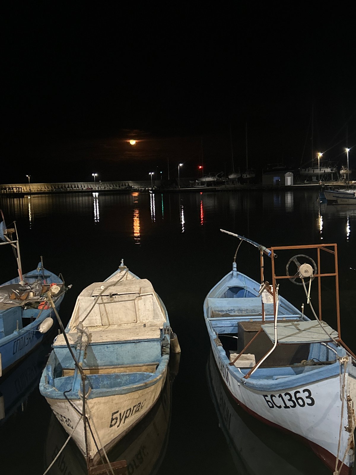 Fishing boats docked at nighttime Burgas harbor pier
