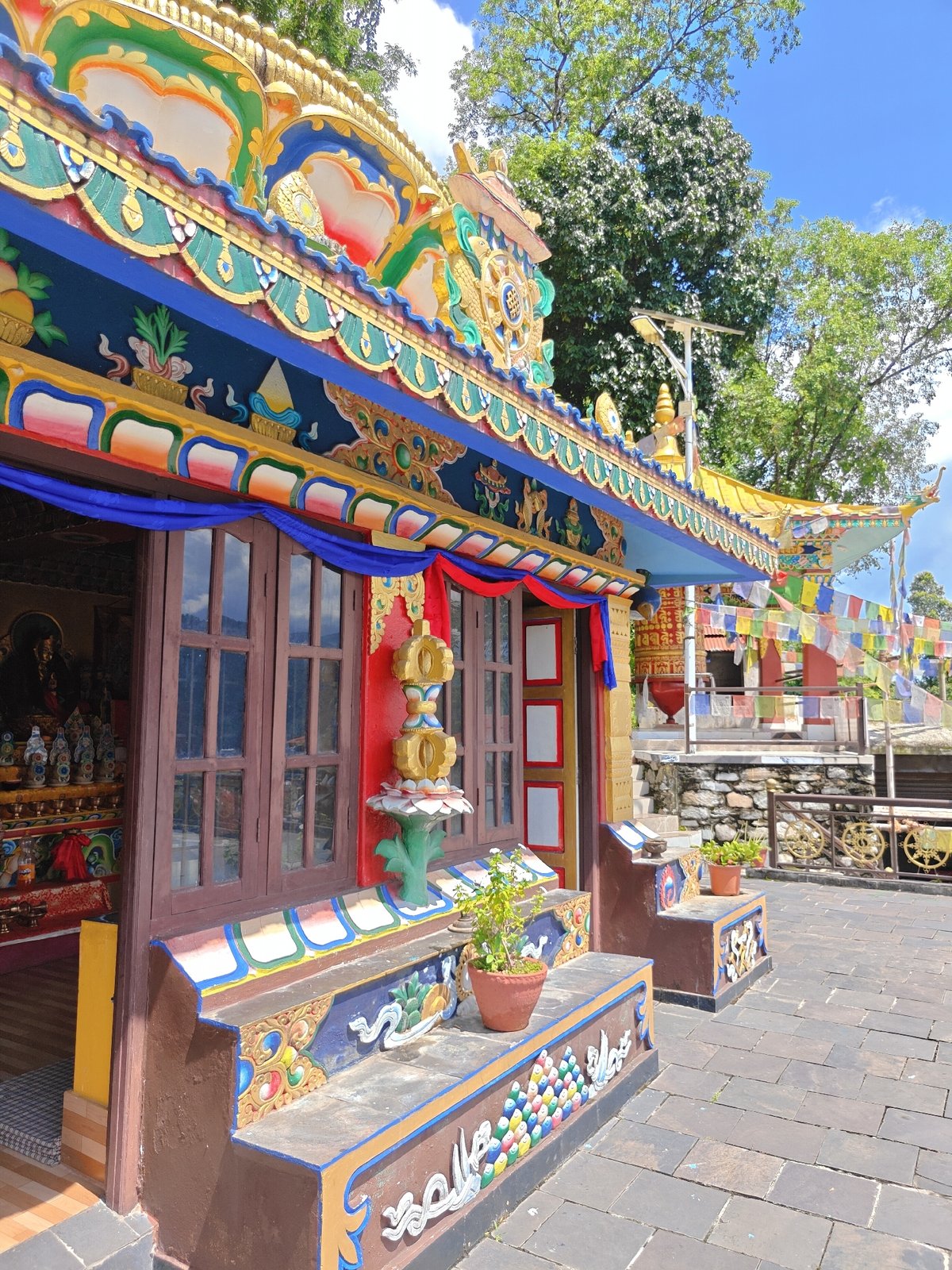 Buddhist temple grounds in Pokhara, prayer flags and lake views
