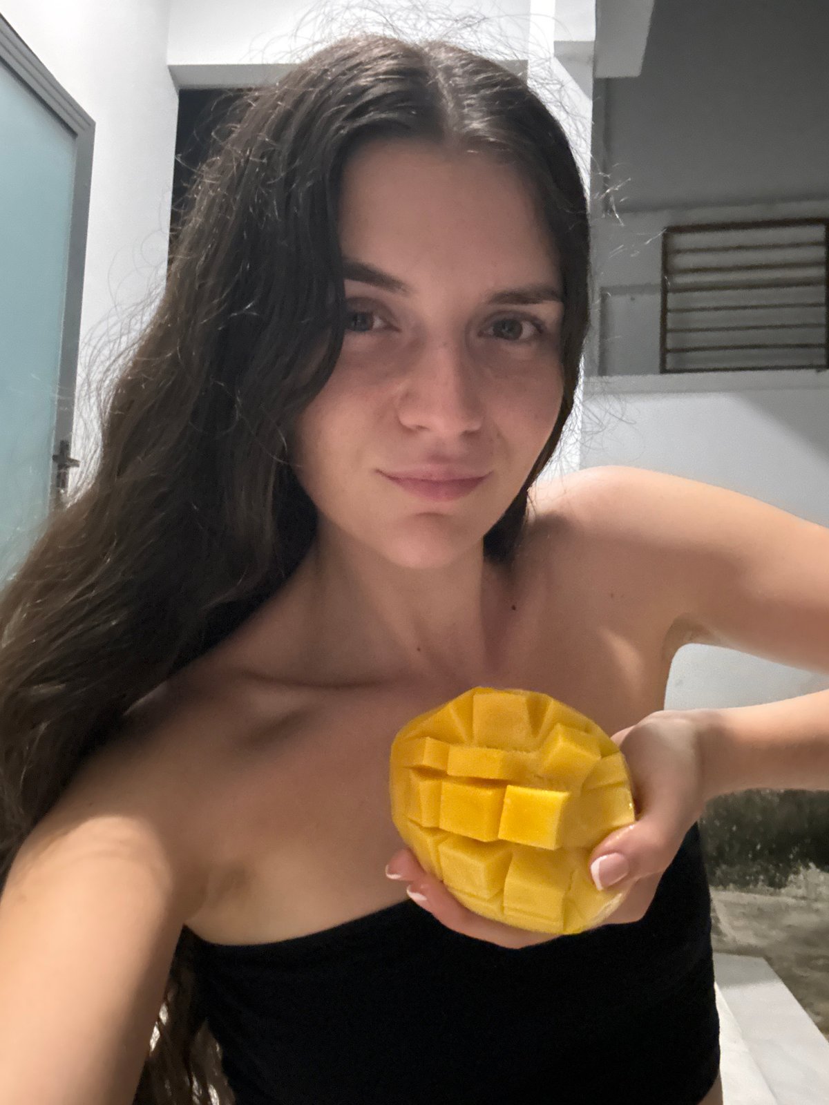 Woman prepares fresh mango indoors in Mũi Né, Vietnam