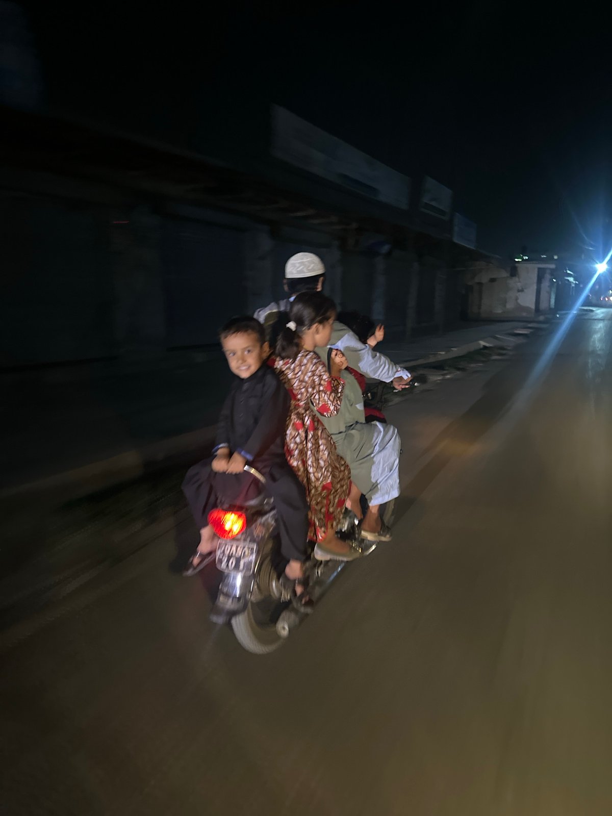 Family rides motorcycle together in Quetta, Pakistan evening