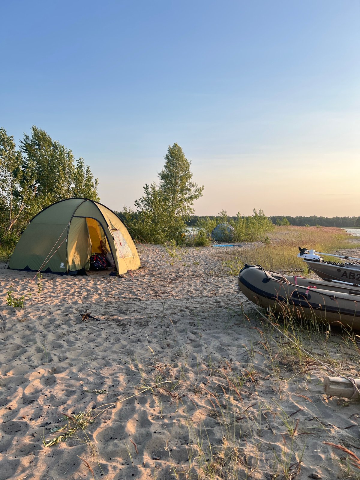 Tent and inflatable boats on a sandy beach near Borovoe