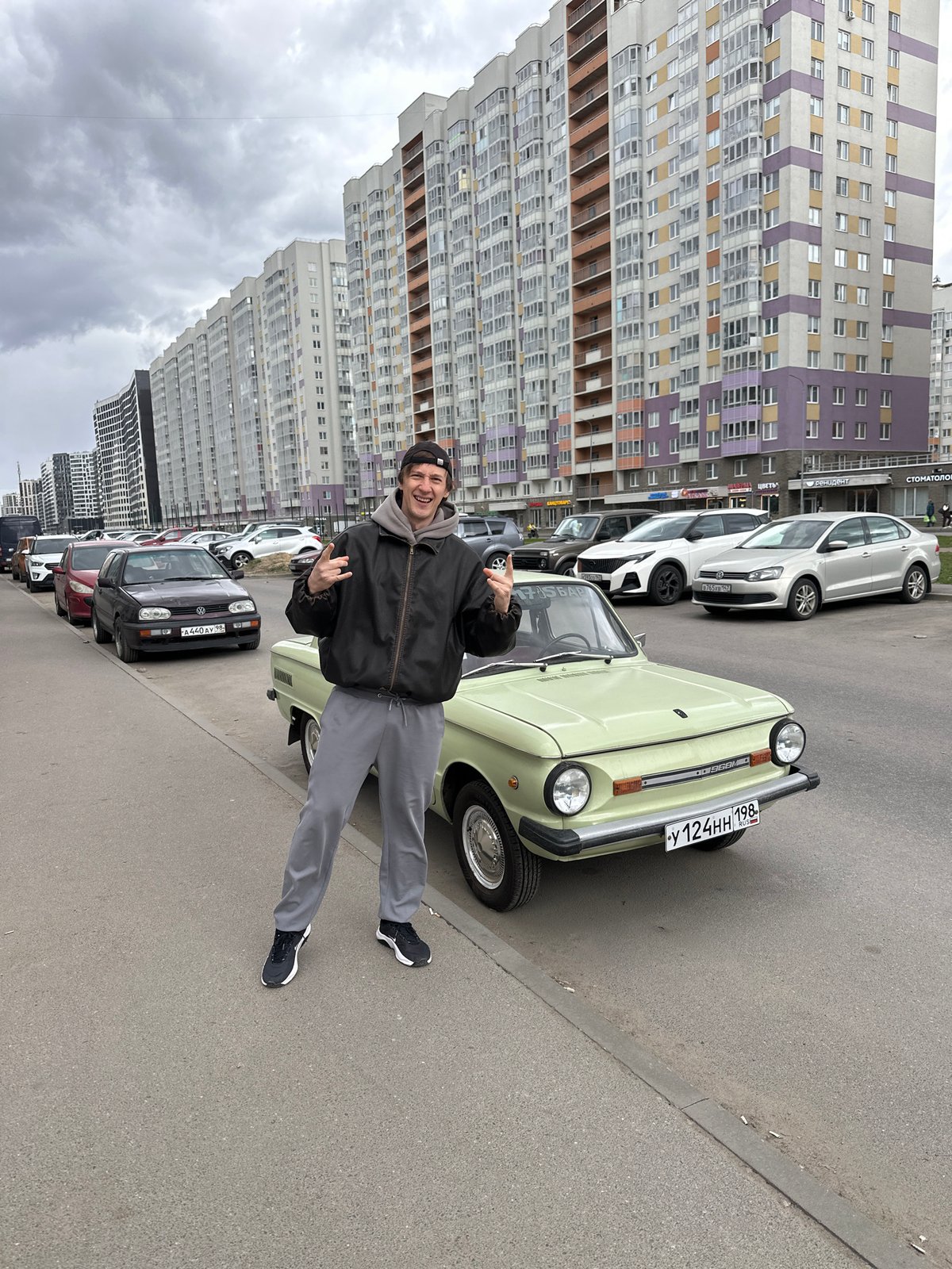 Man poses with vintage green car in Murino