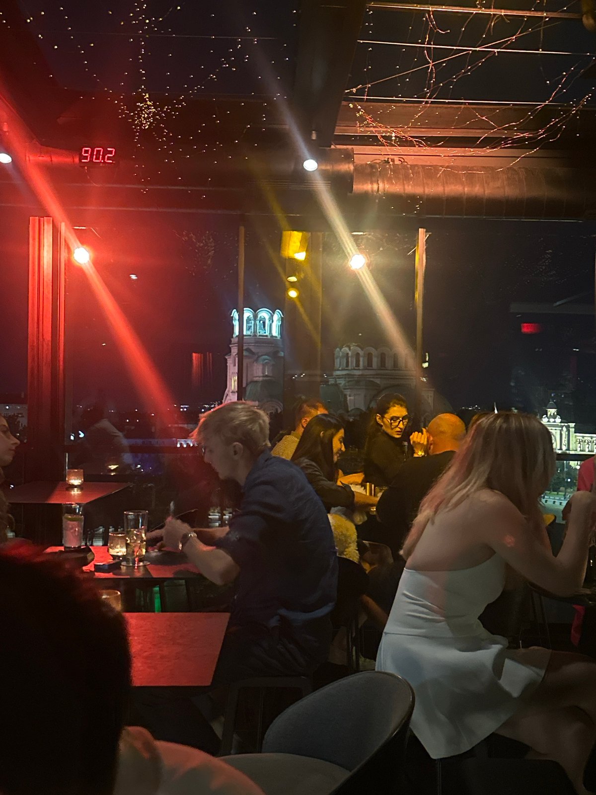 Nighttime bar or restaurant scene with a glowing digital readout