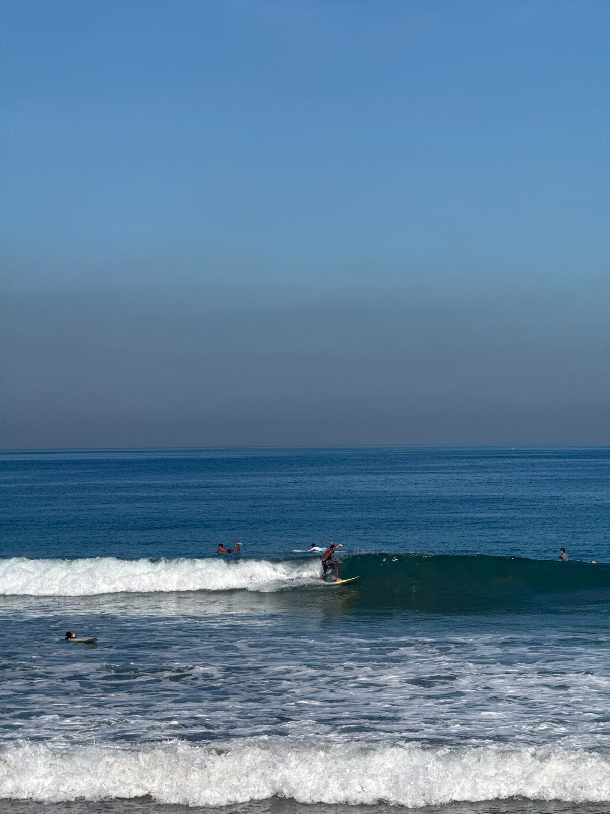Kuta Beach surf session with street activity nearby