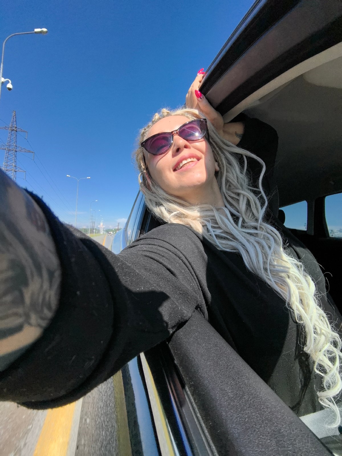 Hanging out a car window on a sunny Russian summer drive