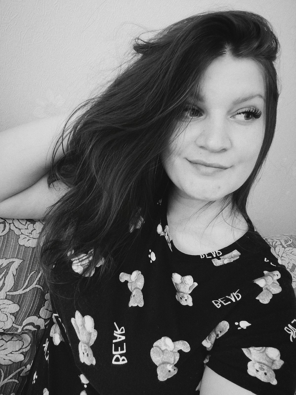 Woman in teddy bear shirt photographed on couch in Tobolsk