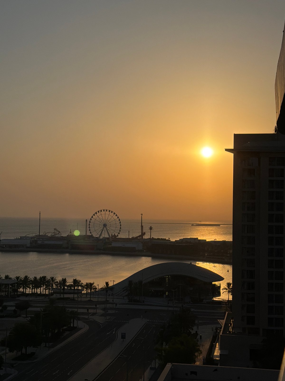 Golden sunset hits Lusail's waterfront pier and Ferris wheel