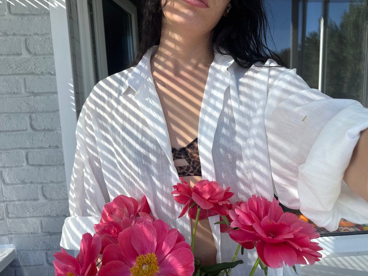 Woman photographs herself with flowers on Chaikovsky balcony