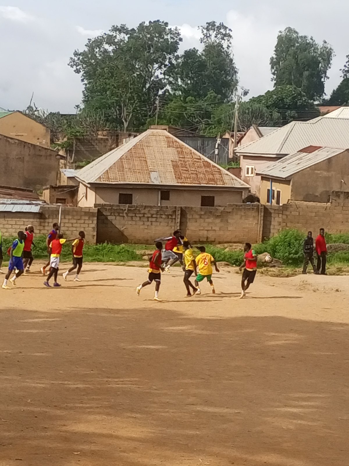 Pickup football on a rocky dirt field in Jos, Nigeria