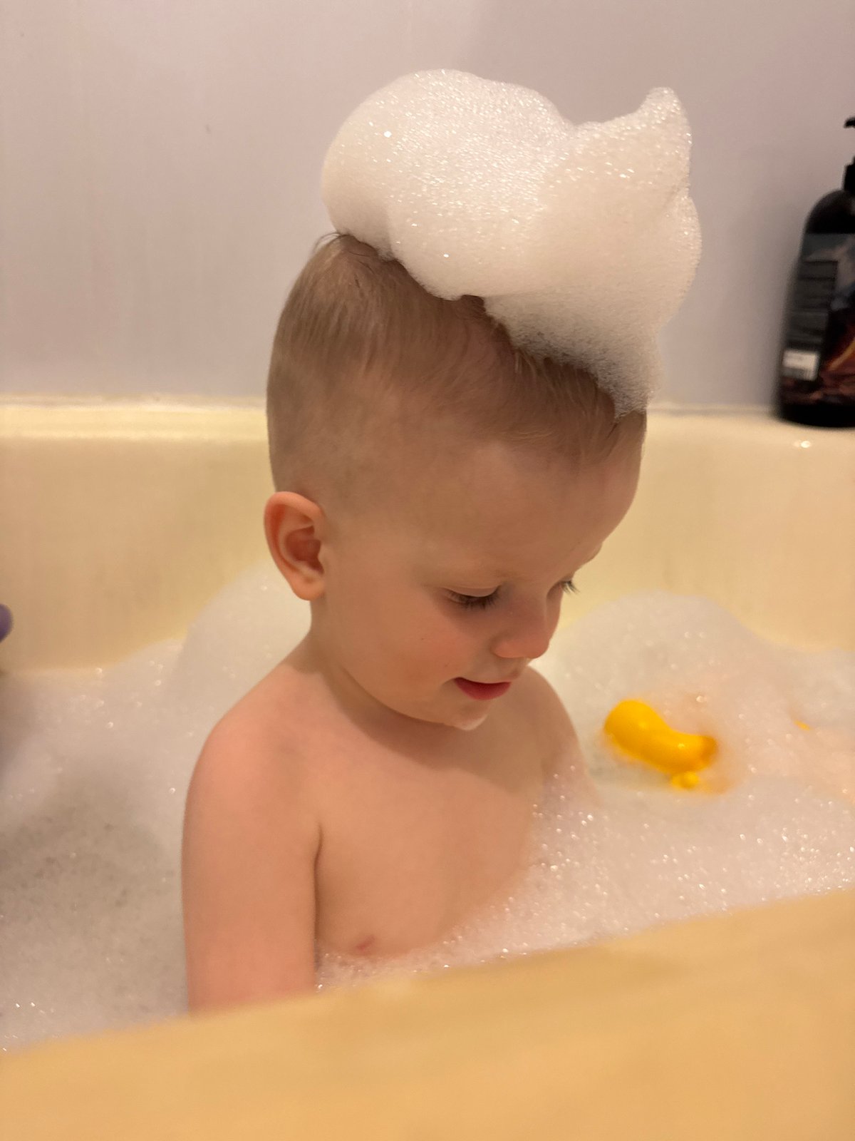 Infant enjoys bubble bath in Saint Petersburg bathtub