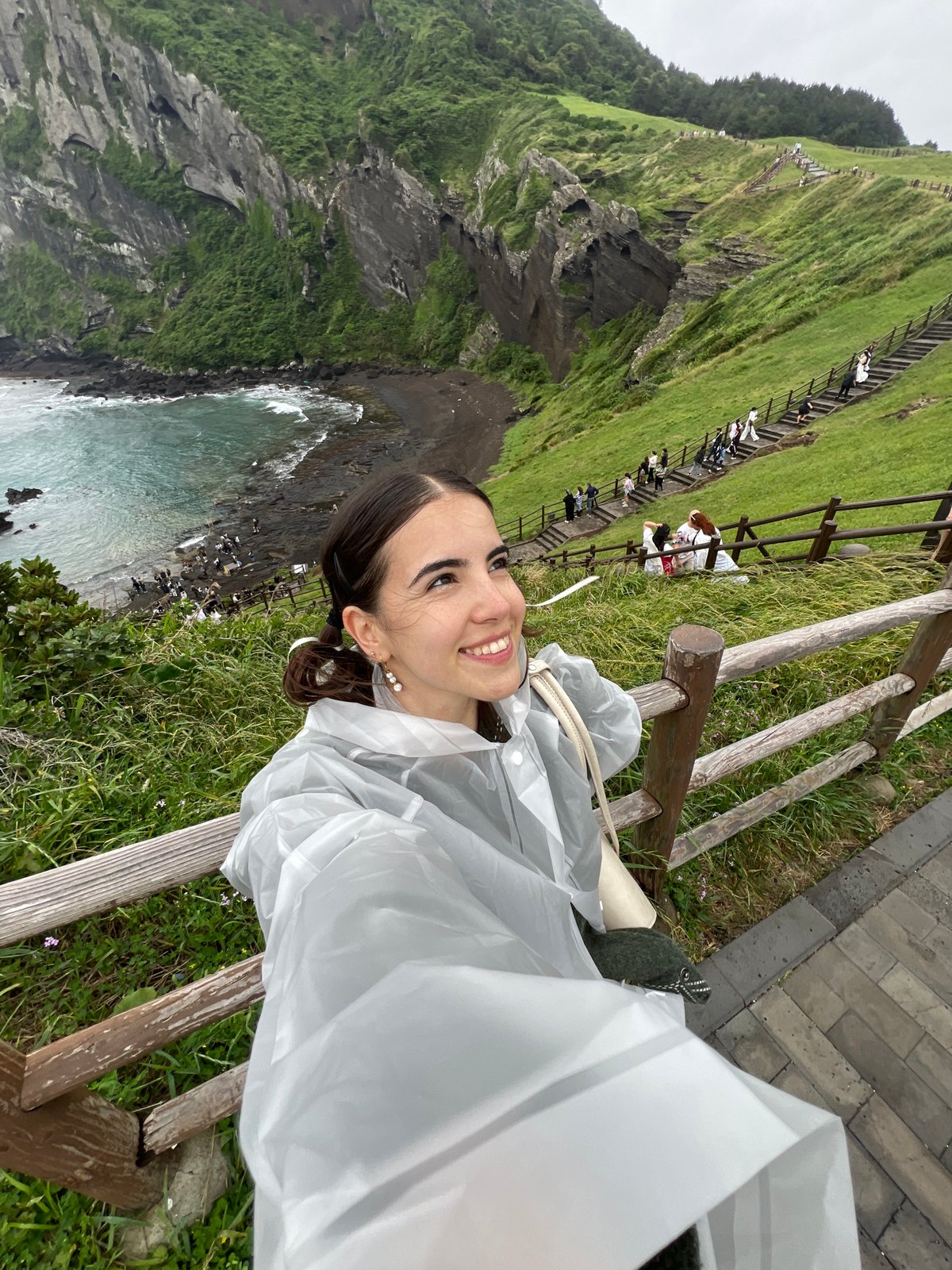 Woman takes selfies at Seogwipo coastal viewpoint early morning