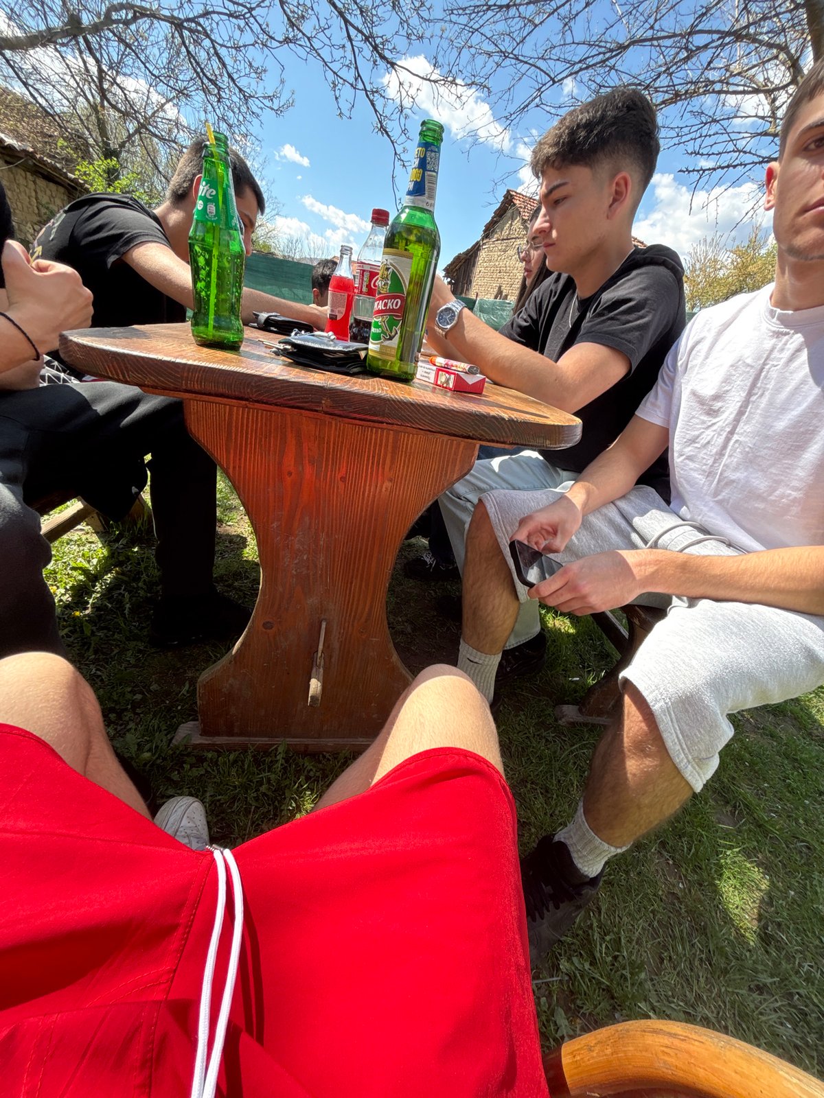 Outdoor gathering observed around wooden table in Dabene, Bulgaria