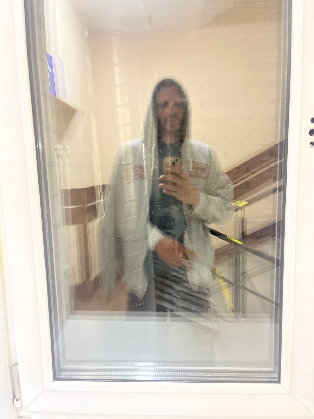 Person photographing through glass panel, composite floor surface documented