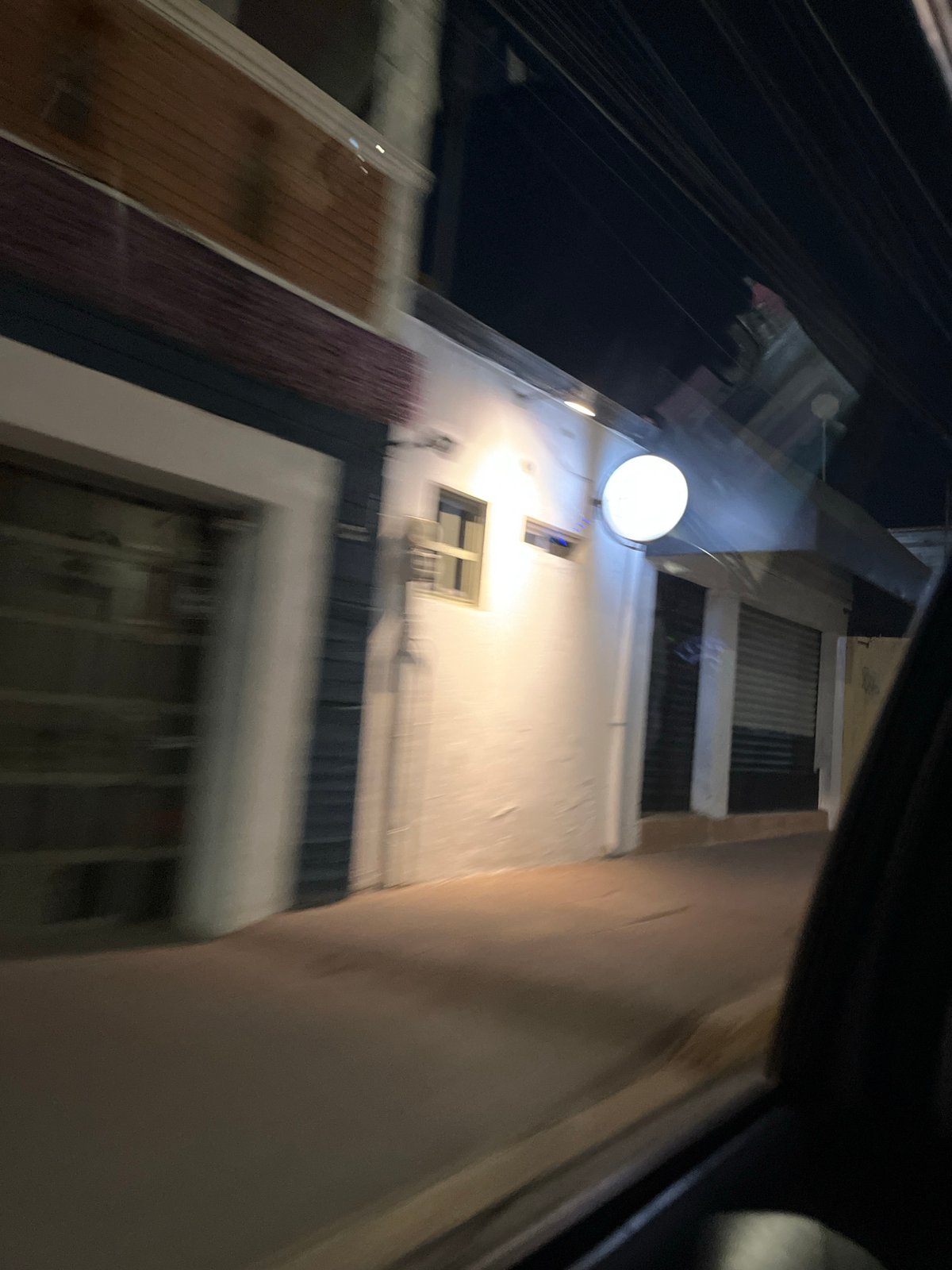 White multi-story building photographed from vehicle in Cholula, Mexico