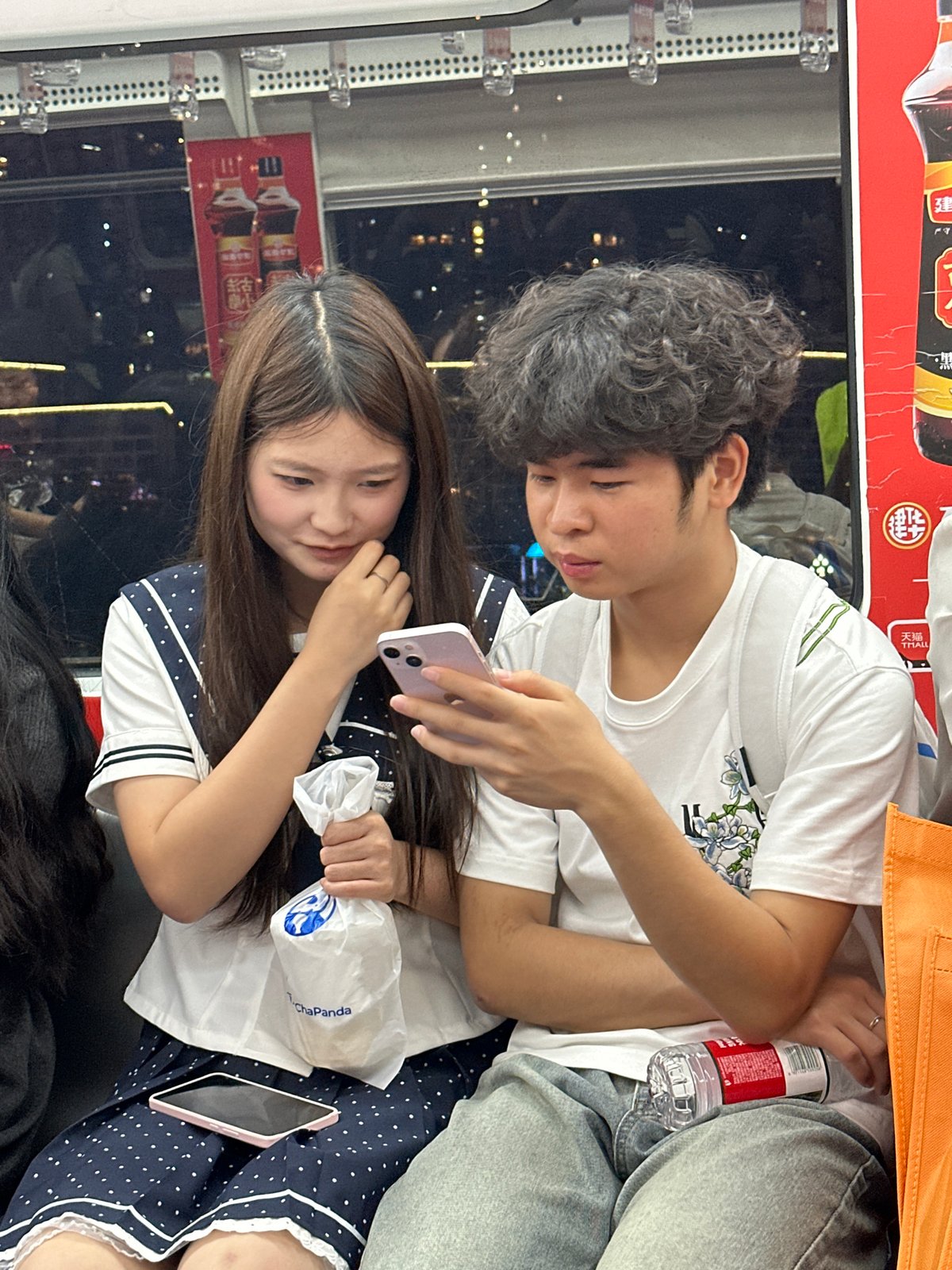 Young couple uses phones on public transit in Chongqing
