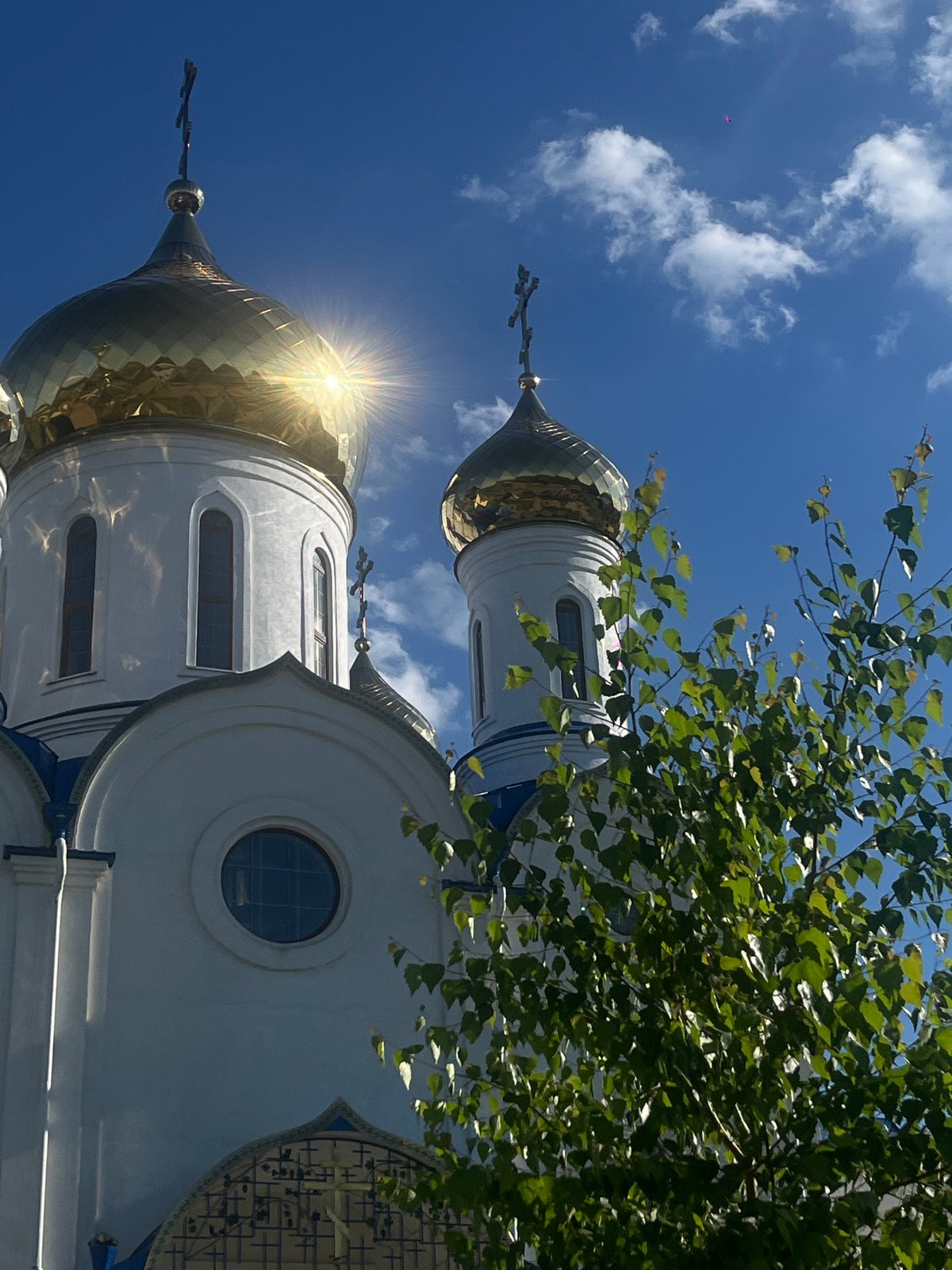 Woman visits Orthodox church gardens in Novopokrovskaya, poses with roses