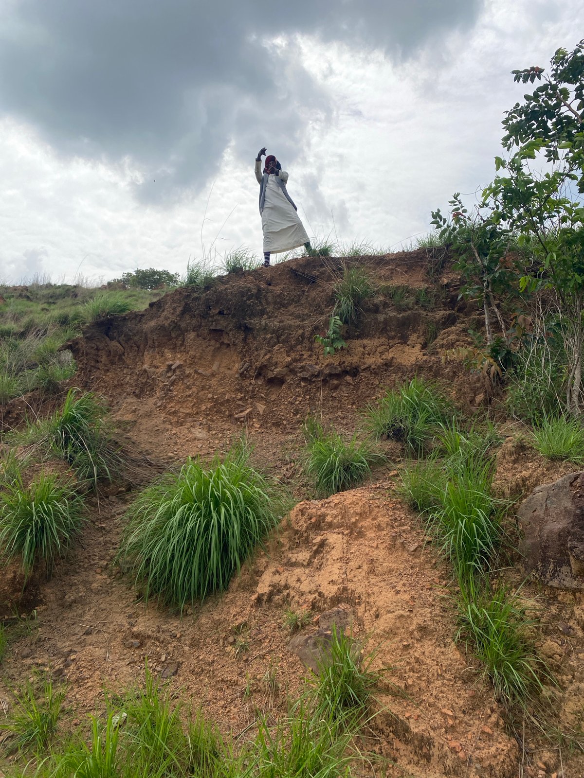 Person traverses steep hillsides in rural Nigeria countryside