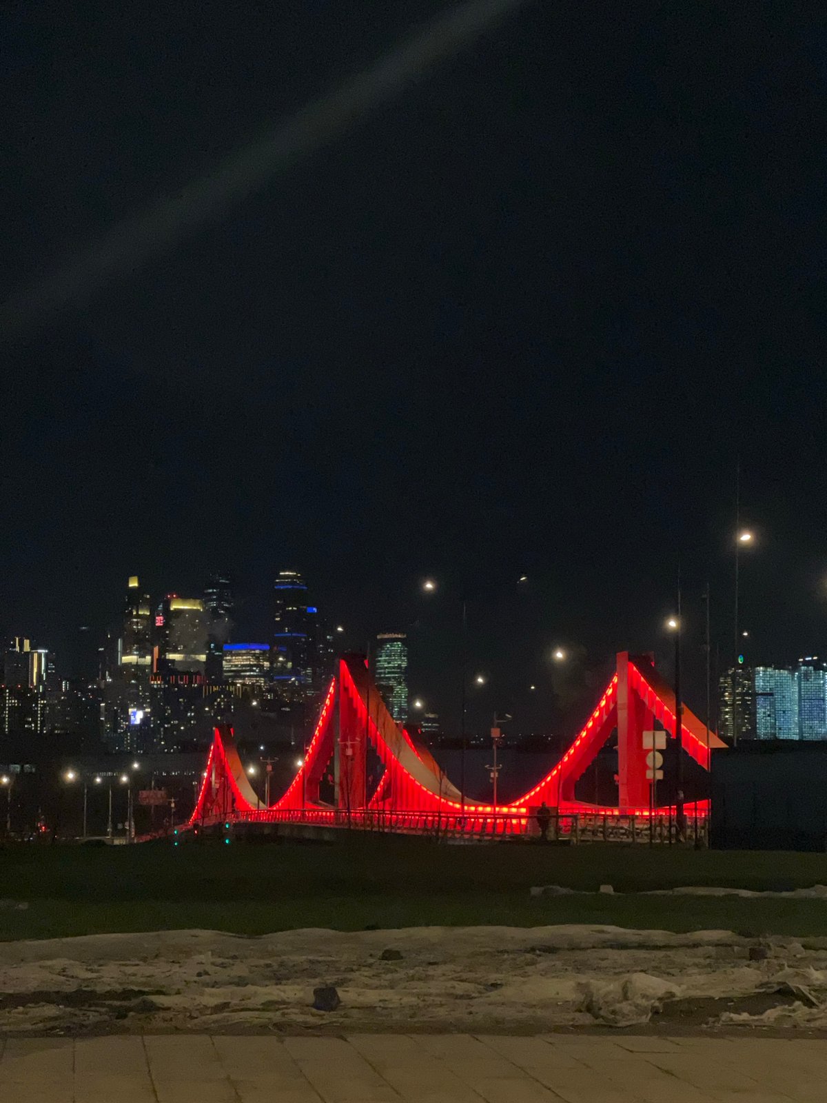 Red illuminated bridge observed at night in Moscow