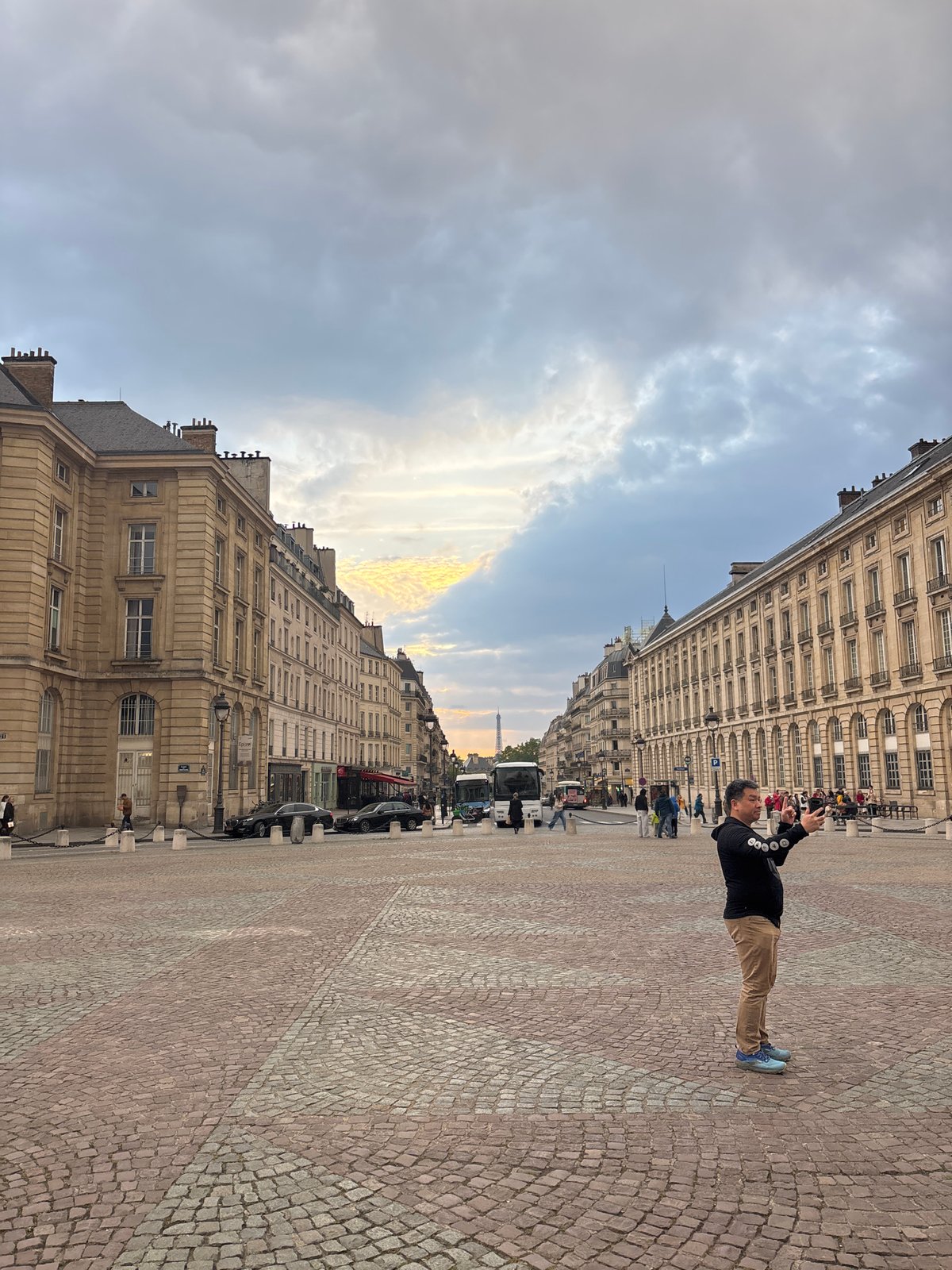Tourist photographs Paris street scene with Eiffel Tower backdrop