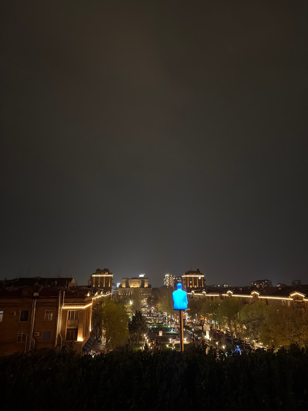 Evening street scene captured in Yerevan with illuminated sculpture