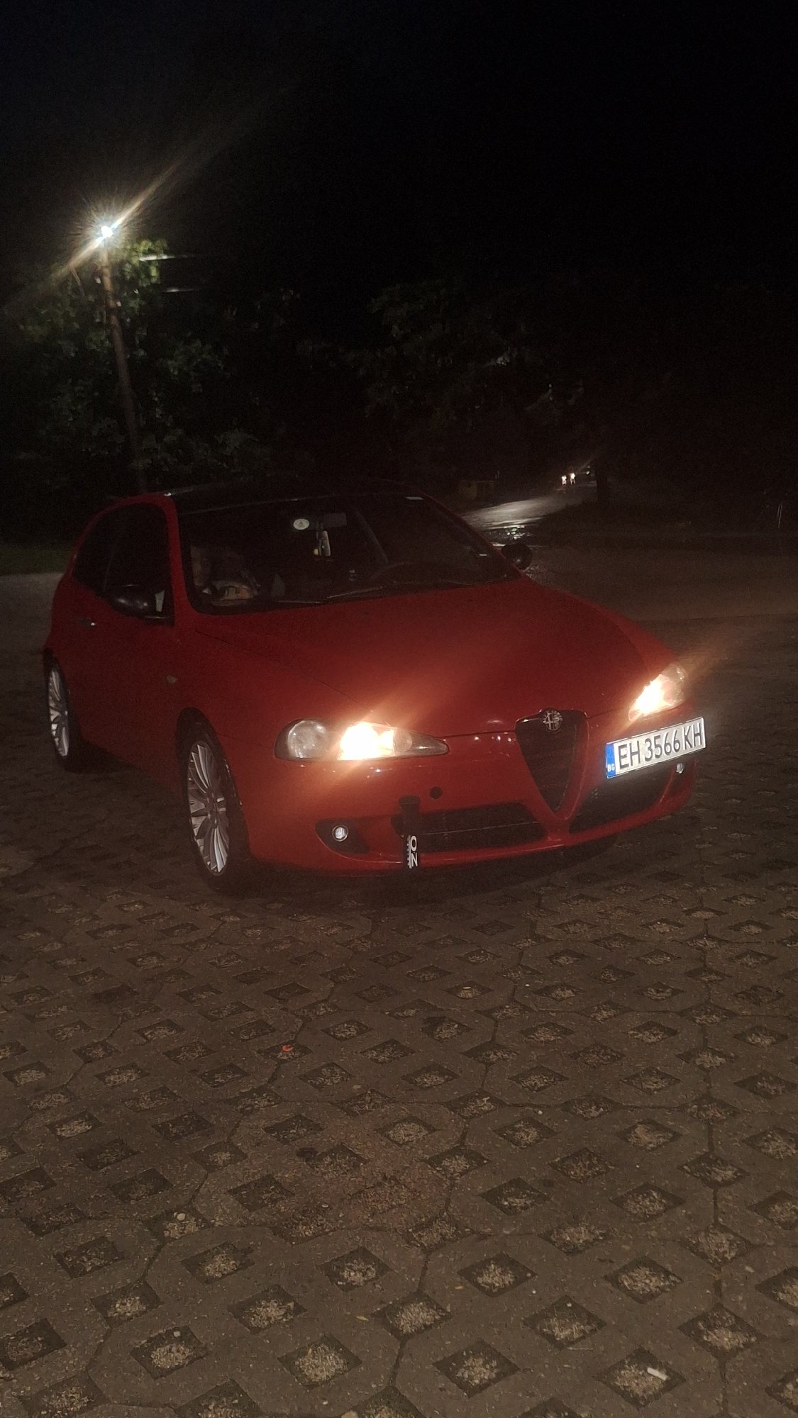 Parked car and shop window at night, July 2026