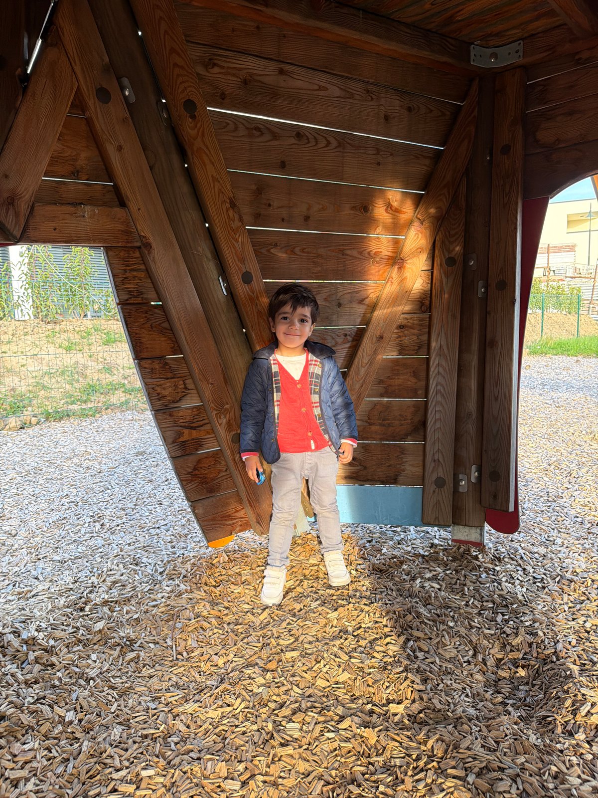 Child plays at wooden playground in Junglinster, Luxembourg