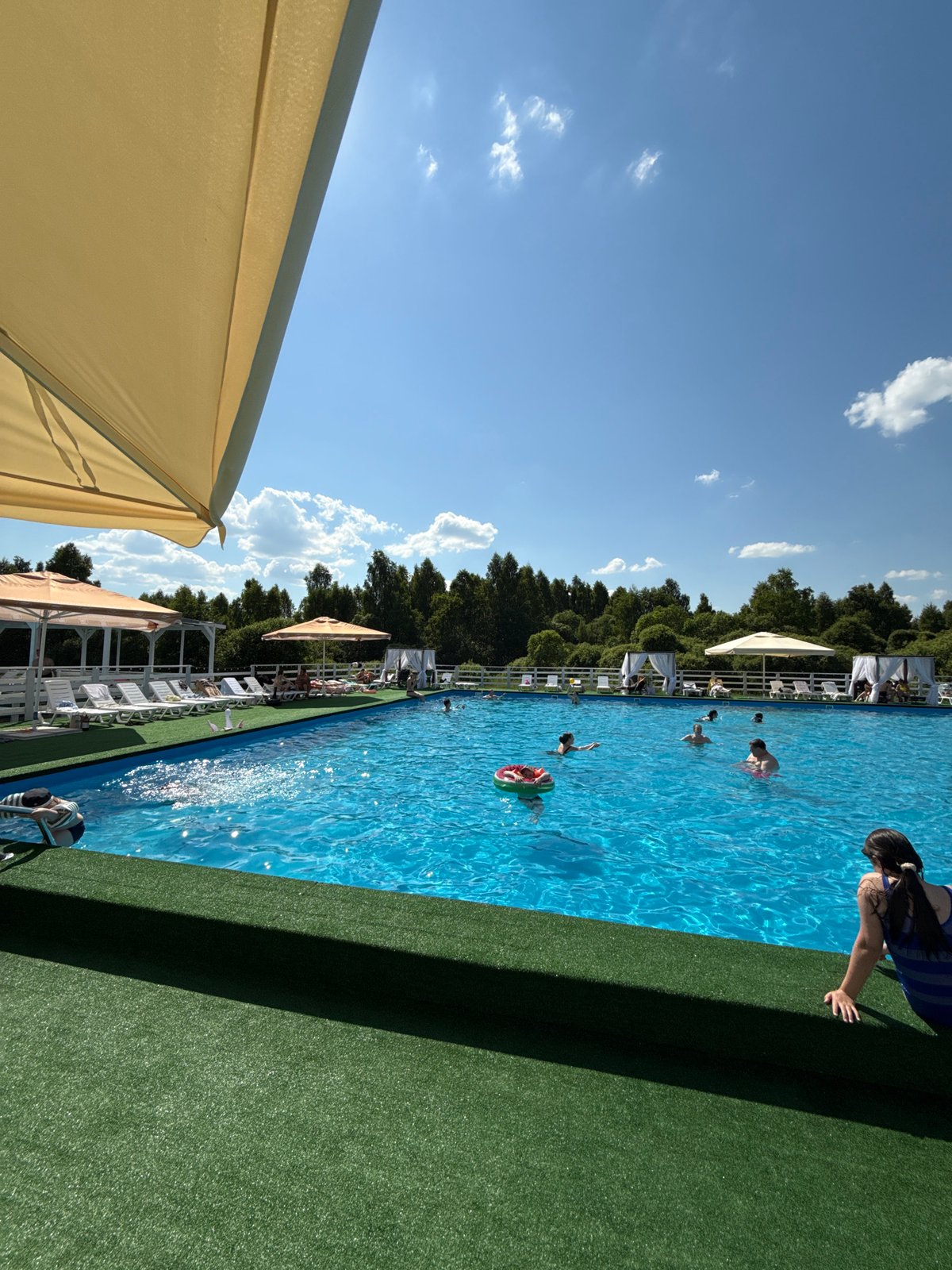 Child enjoys poolside time with smartphone in Koloksha, Russia