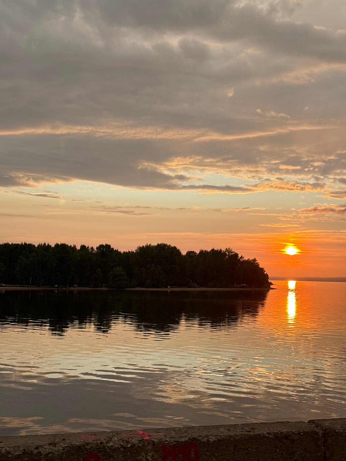 Sunset colors spread across the water near Noviy, Russia