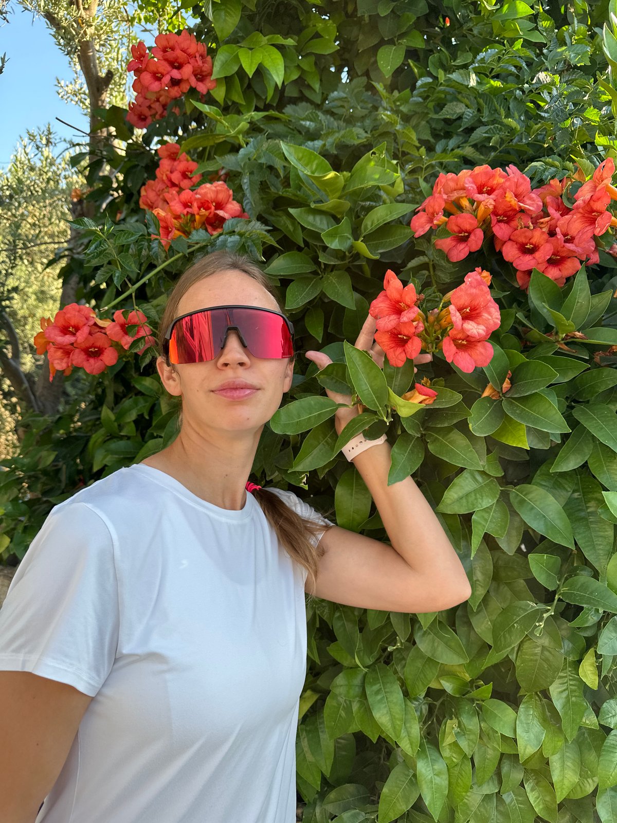 Woman waves under bougainvillea tree in Fethiye, Turkey