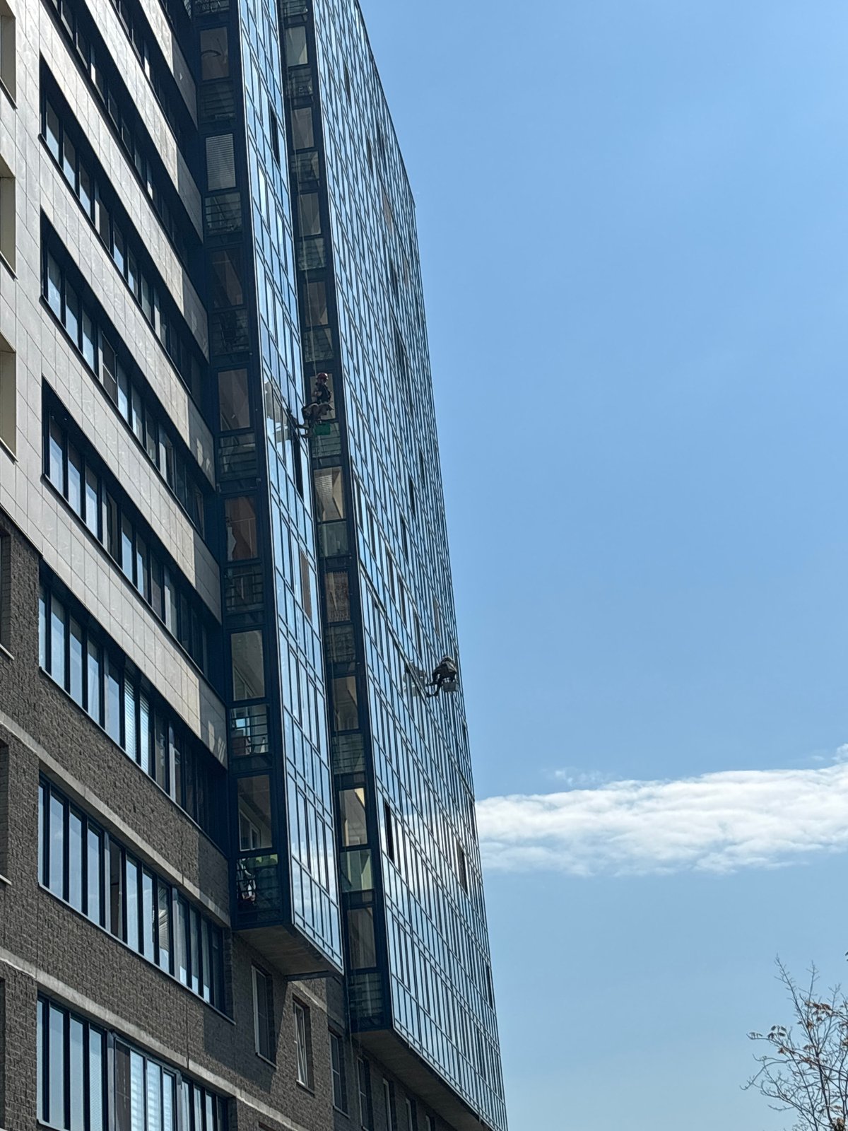 Window washers clean tall building in Vsevolozhsk, Russia