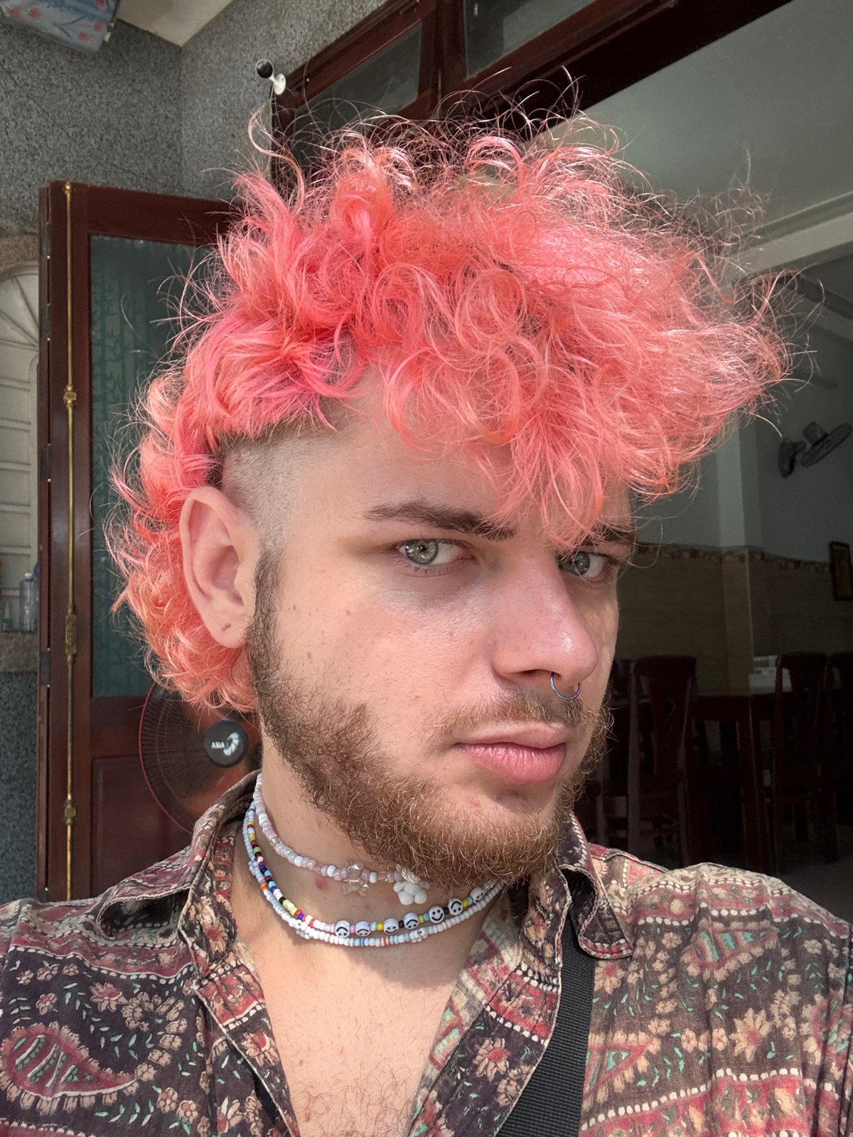 Pink-haired individual photographed on Đà Nẵng street near motorbikes