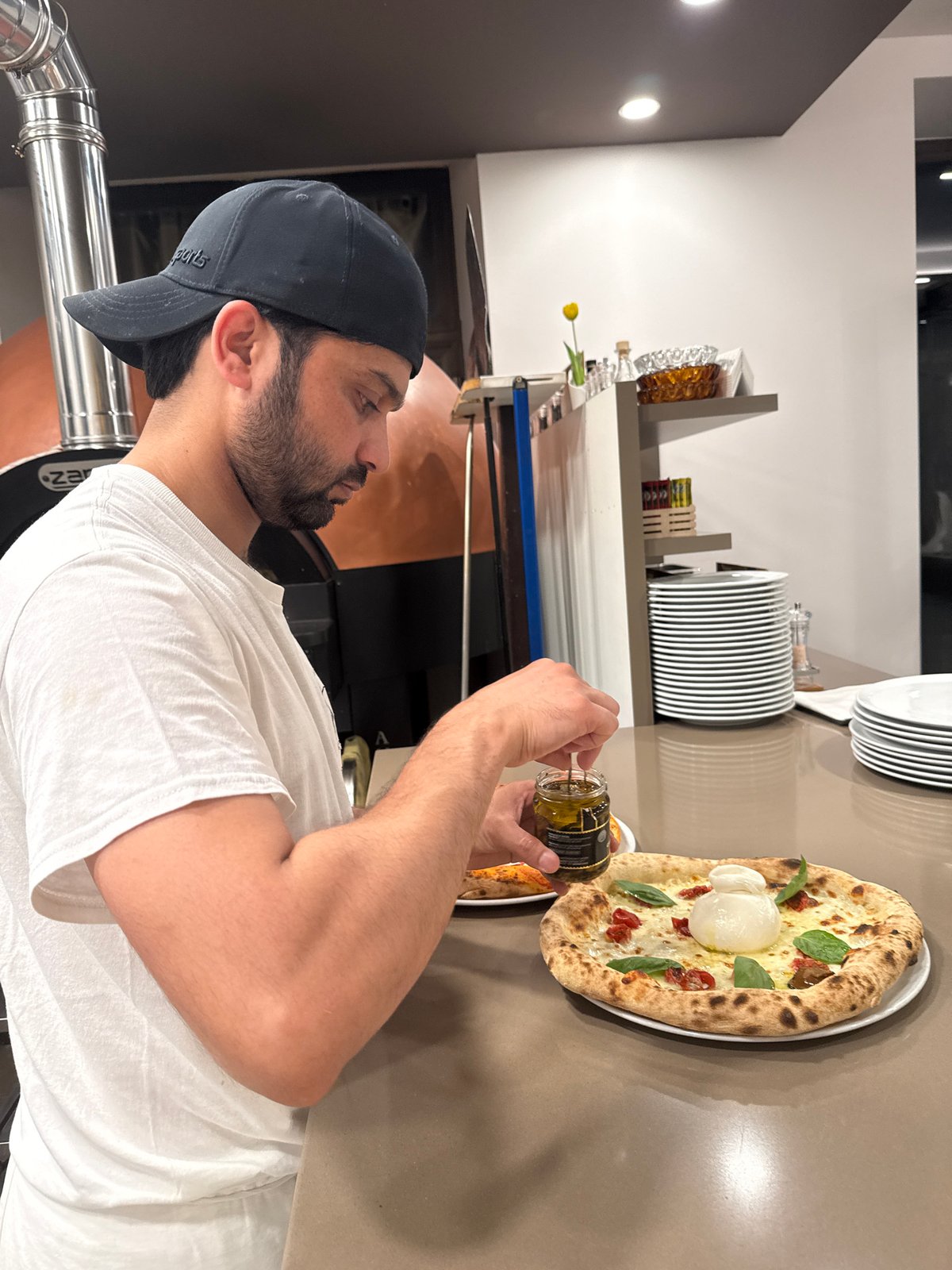 Behind the counter at a Trento pizzeria, craft pies take shape