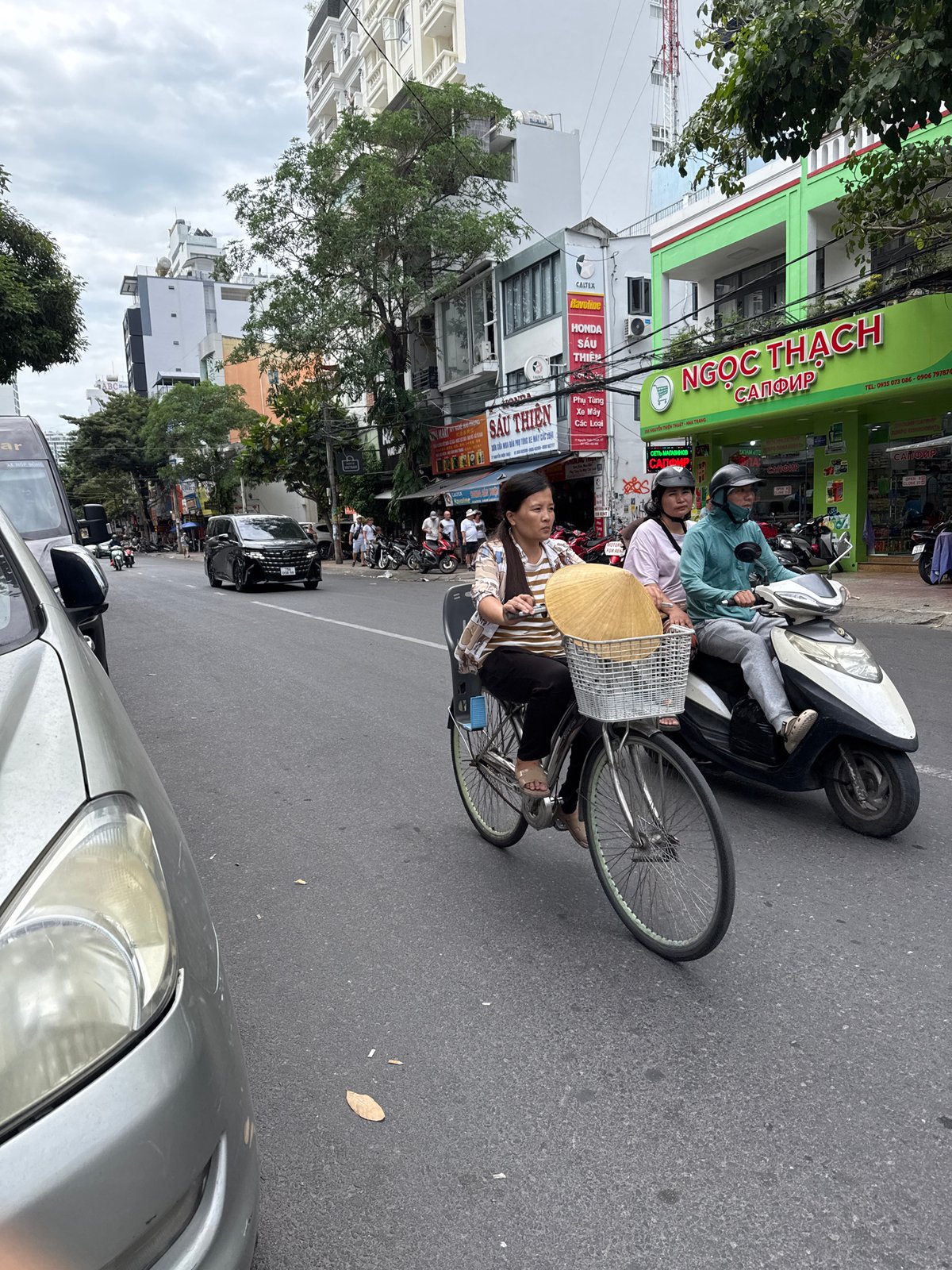 Nha Trang street traffic: cyclists and a waste collection motorcycle