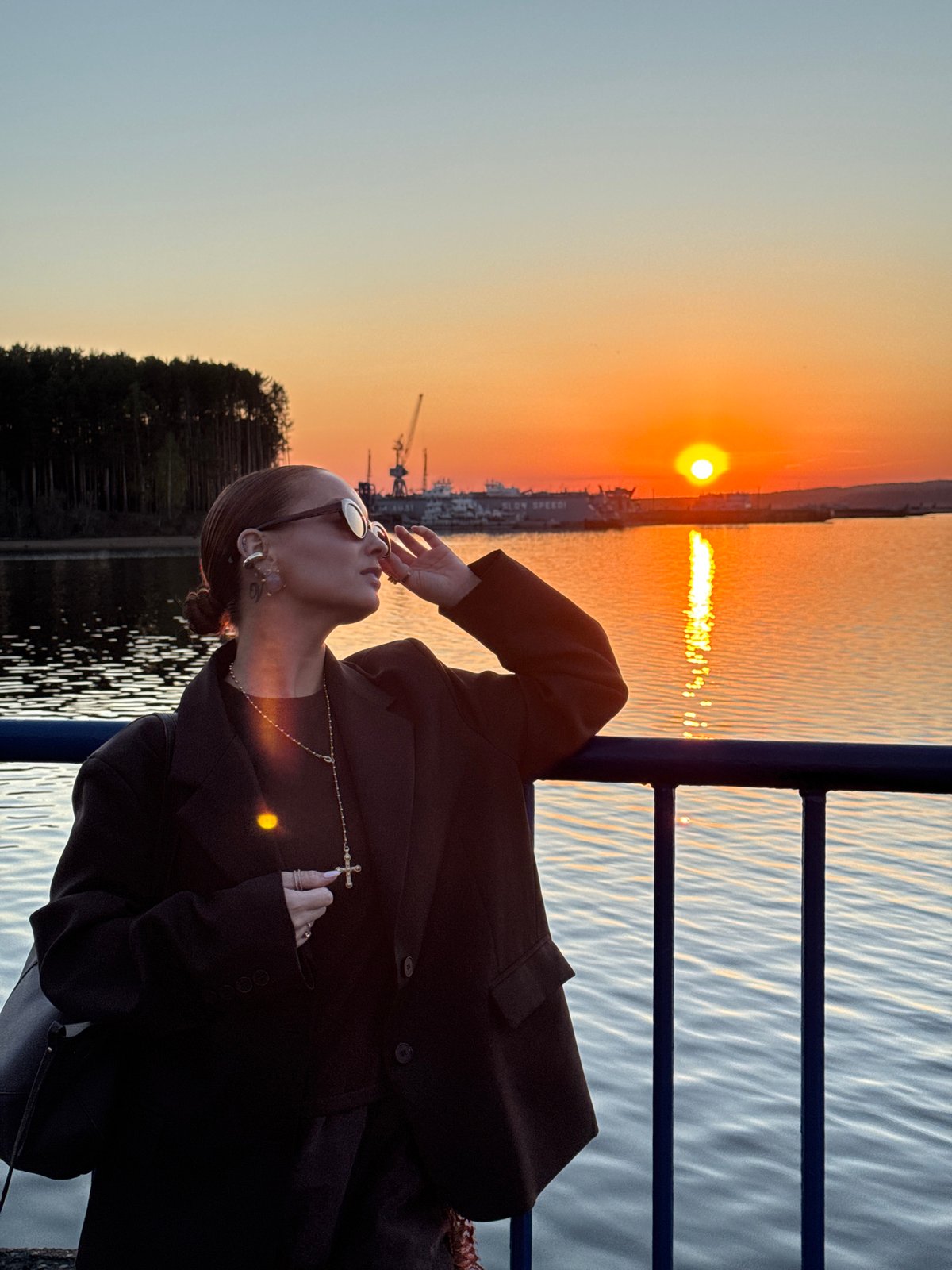 Woman captures sunset selfies along Kama River in Chaikovsky