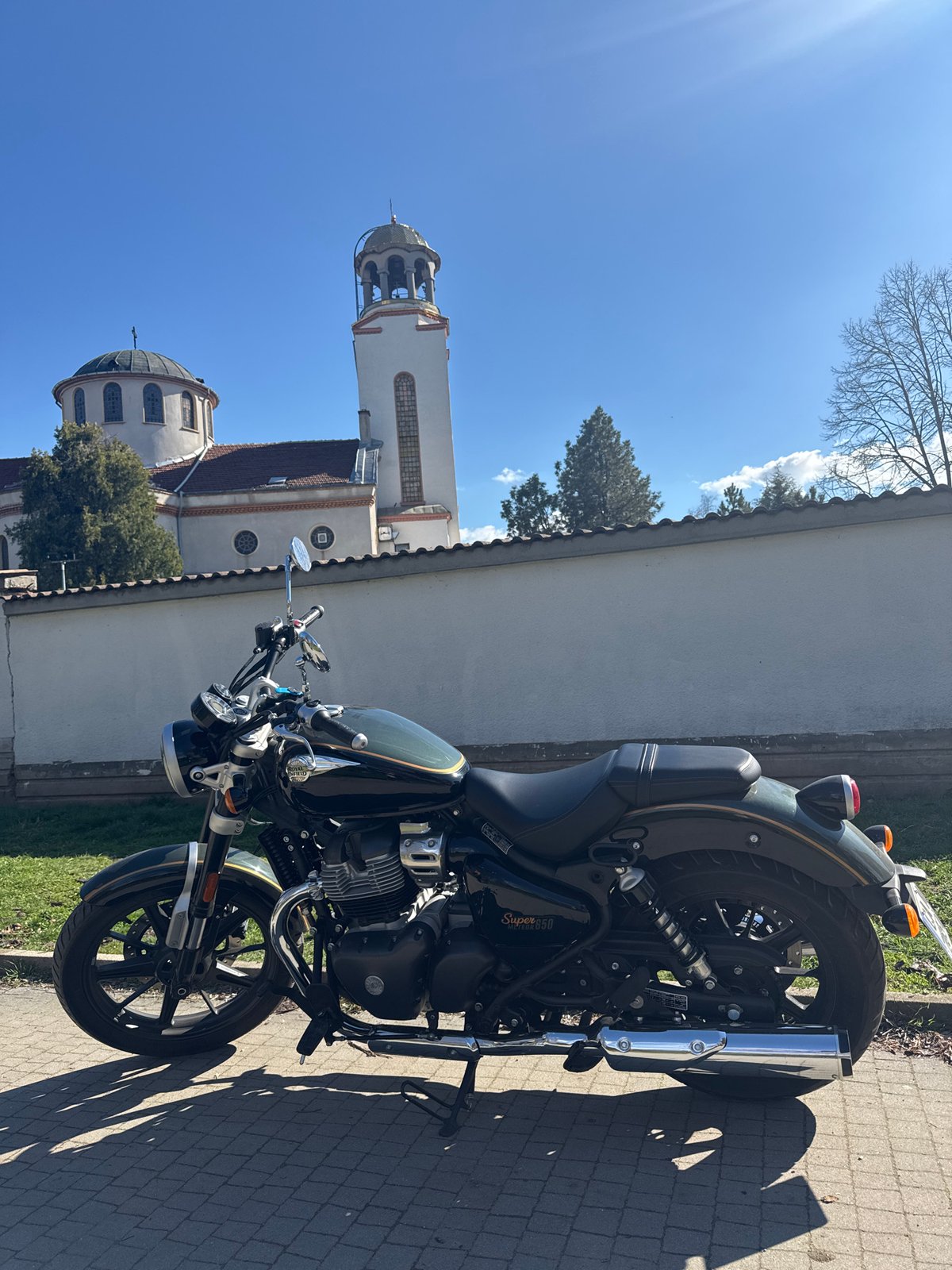 Motorcycle parked near Russian church in Sofia amid spring blooms