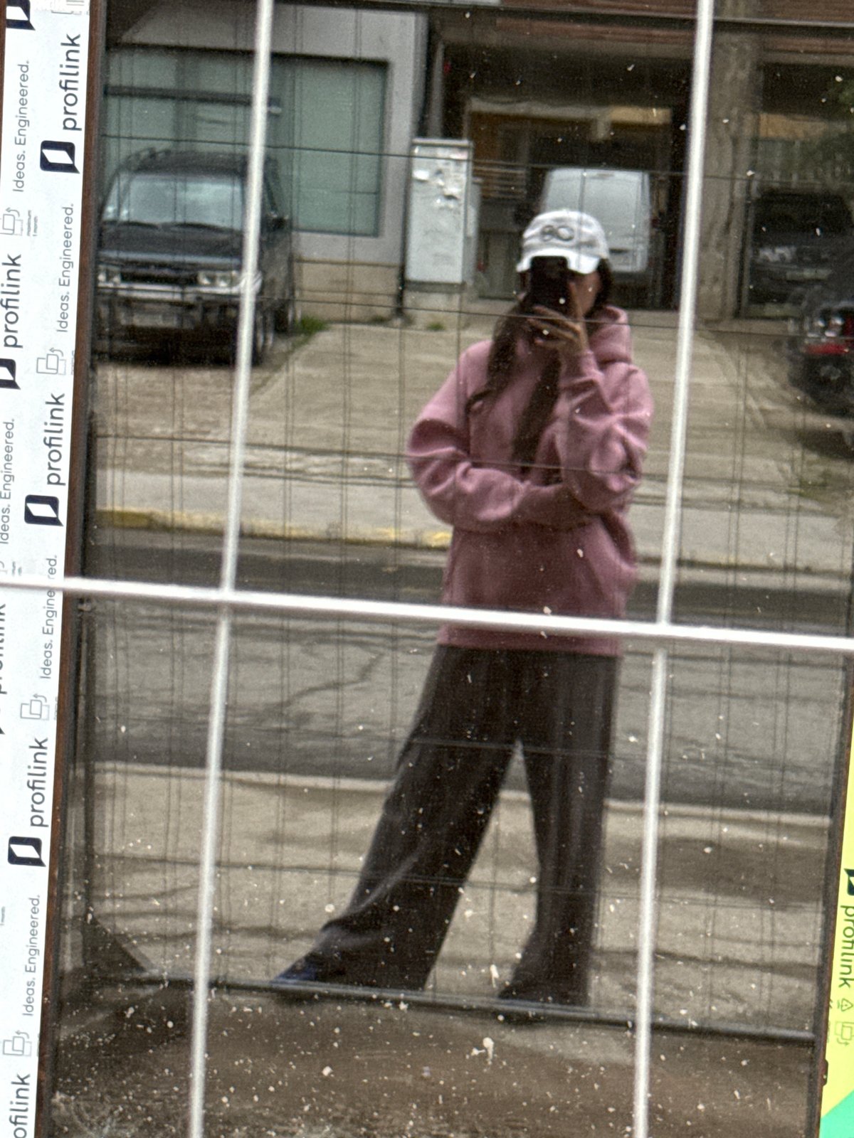 Person's reflection captured in grimy glass surface in Plovdiv