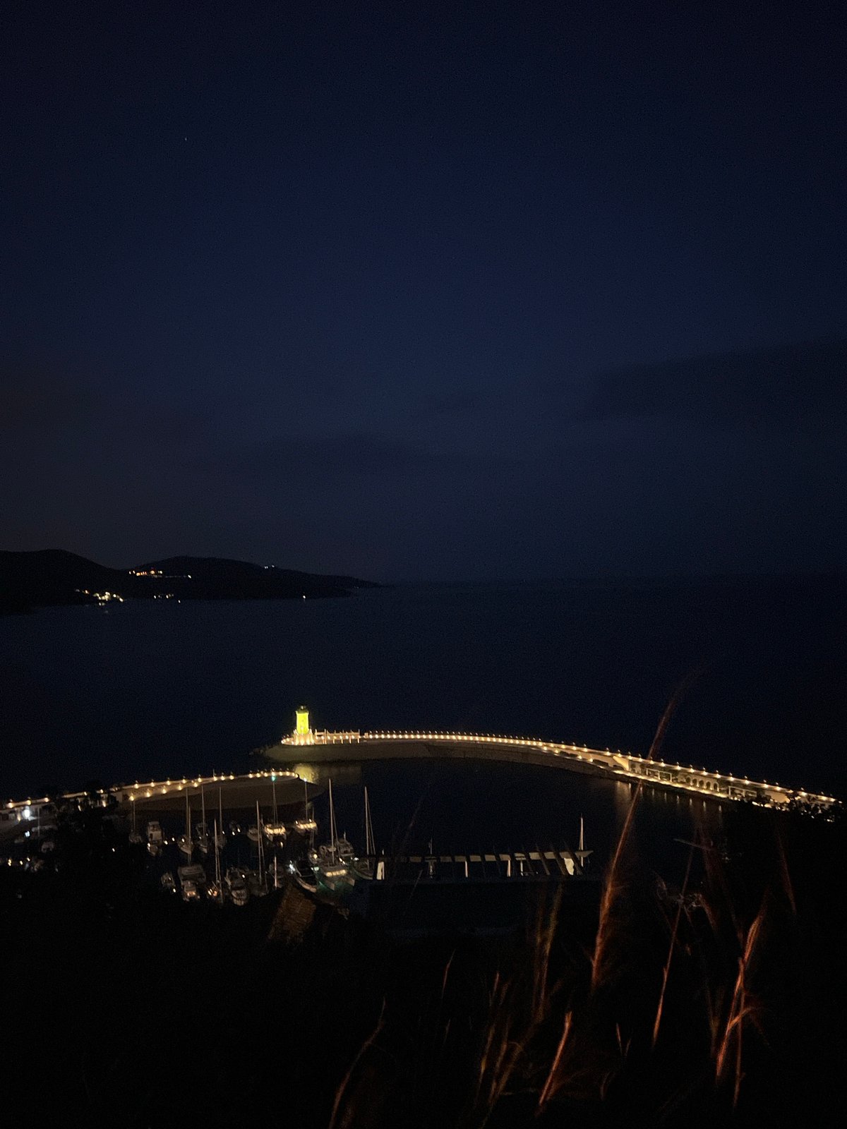Evening lights illuminate Porto Montenegro marina and construction crane