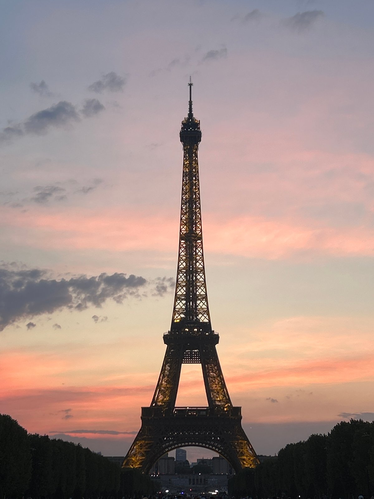 Eiffel Tower glows warm against a purple-pink dusk sky