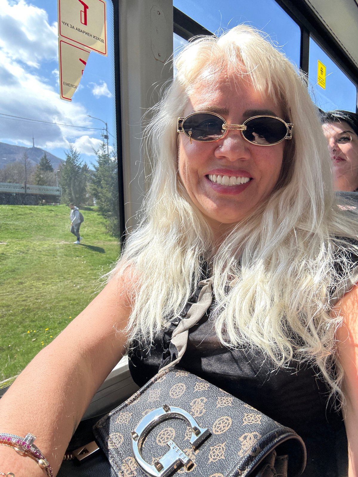 Woman rides public bus in Sofia with mountain views