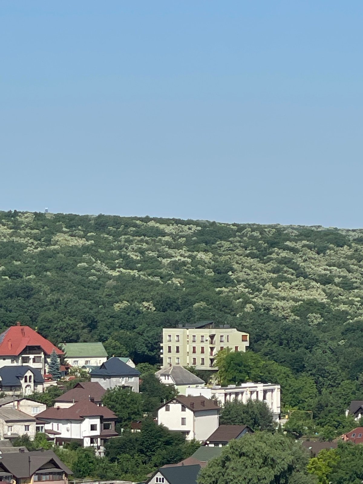 Aerial sweep of a hilly residential neighborhood on a clear morning