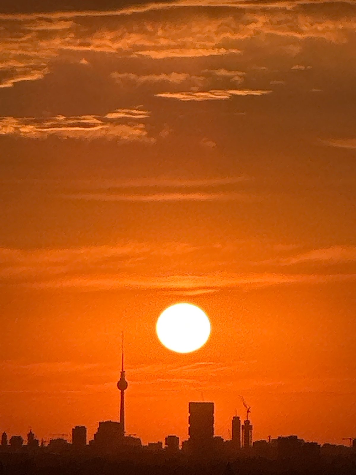 Berlin skyline glows orange as the sun sets low