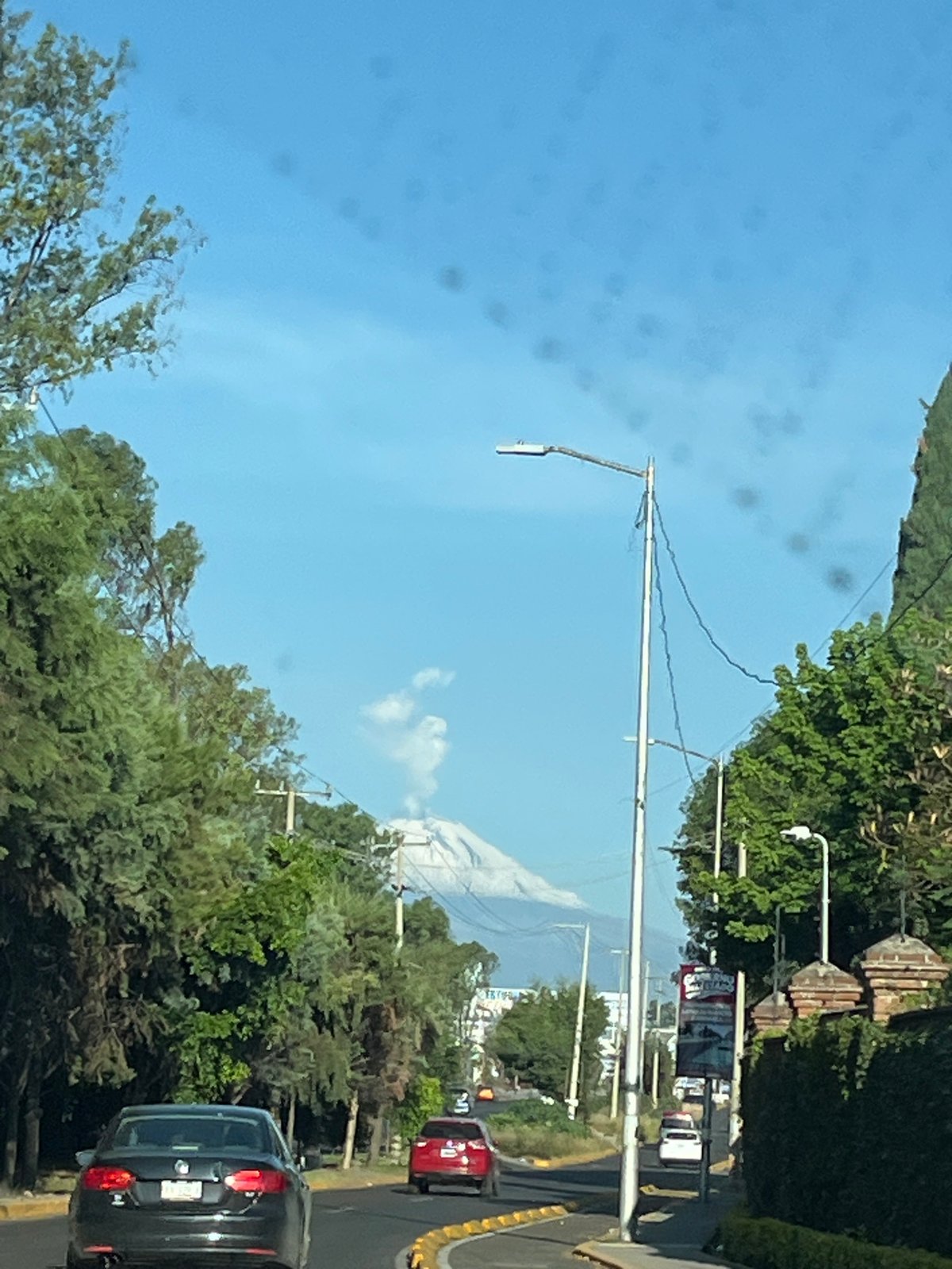 Everyday street scene captured in Puebla with Popocatepetl backdrop